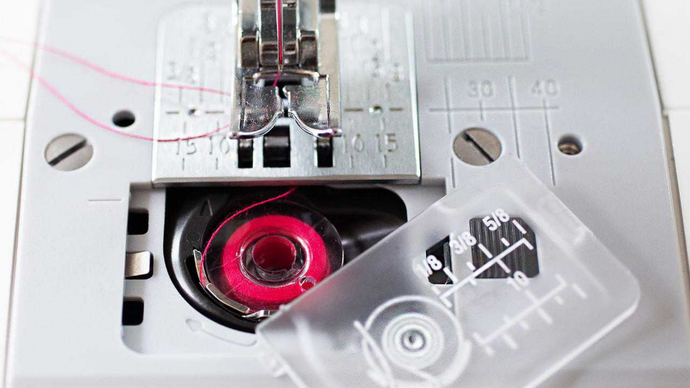 Close-up of a sewing machine needle and thread mechanism.