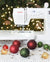 Sewing machine with Christmas ornaments on a table in front of a decorated tree.